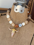 Jennifer Thames chunky neutral beaded necklace with gold and blush bull skull pendant
